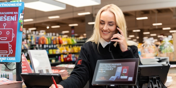 Trainee pri telefonickom rozhovore na info pulte v predajni