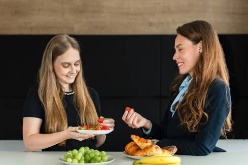 zamestnankyne v kuchynke pri raňajkách s ovocím a pečivom