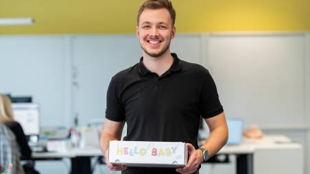 Odborný asistent drží darček pre svoje novonarodené dieťa