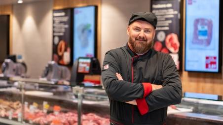 pracovník oddelenia pultov pre pultom s mäsom v pracovnom oblečení