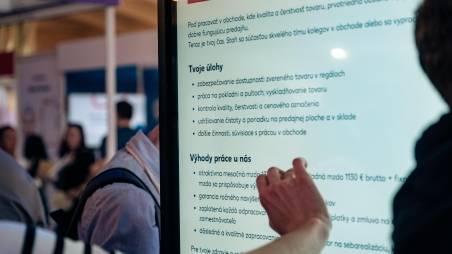 Kandidát si číta popis pozície na tabuli na kariérnom evente