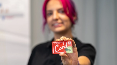 Pracovníčka marketingu drží v ruke vernostnú kartu Kaufland Card